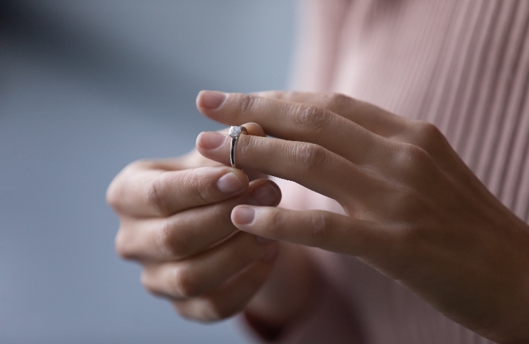 woman takes off wedding ring